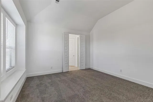 an empty room with windows and closet