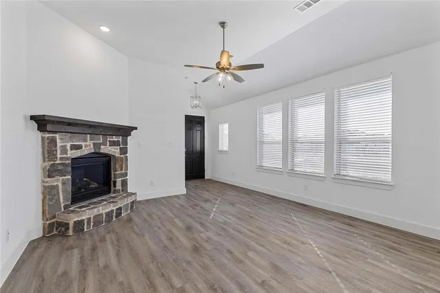 wooden floor fireplace and windows in an empty room