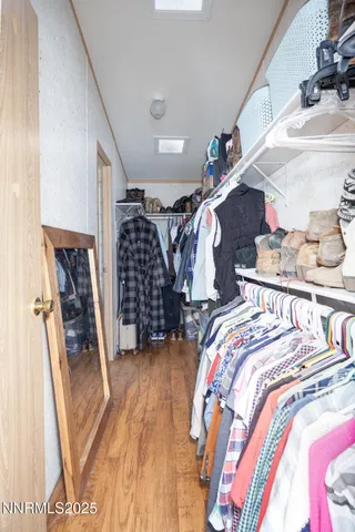 a view of walk in closet with clothes and shoes