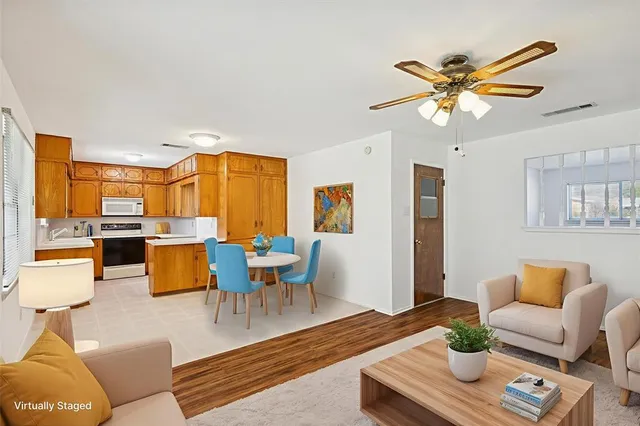 a living room with furniture kitchen view and a window