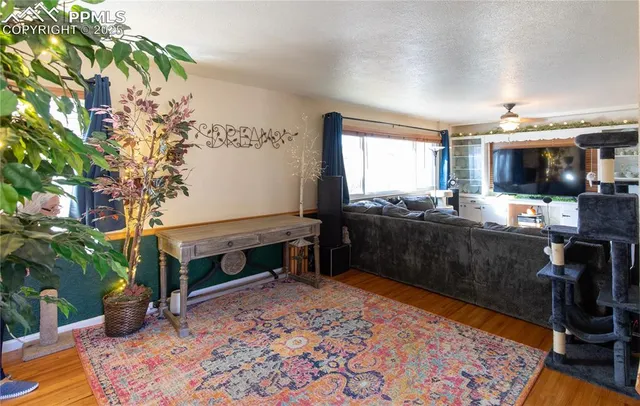 a living room with furniture a flat screen tv and a fireplace