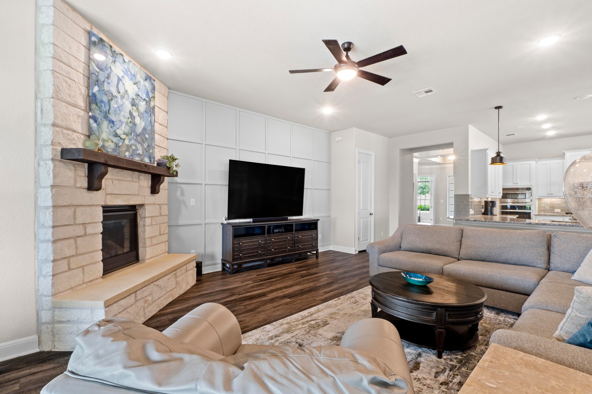 1329 Siena Sunset Road Leander, TX 78641 - Photo 4 of 33 a living room with furniture and a flat screen tv with kitchen view