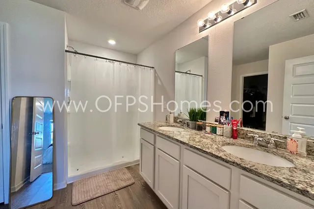 a bathroom with a granite countertop sink and a mirror