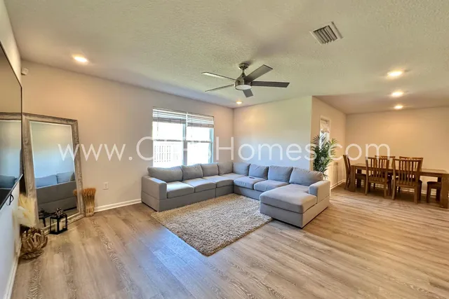 a living room with furniture and wooden floor
