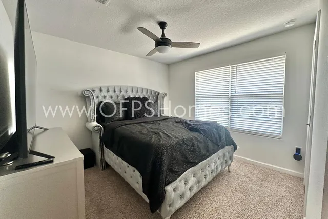 a bed sitting in a bedroom next to a window