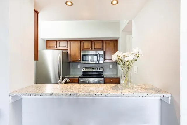 a kitchen with granite countertop a refrigerator and a sink