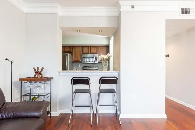 a kitchen with stainless steel appliances a dining table chairs and a refrigerator