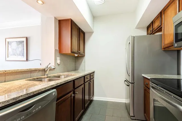a kitchen with stainless steel appliances granite countertop a sink stove and refrigerator
