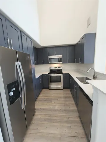 a kitchen with stainless steel appliances granite countertop a refrigerator sink and stove