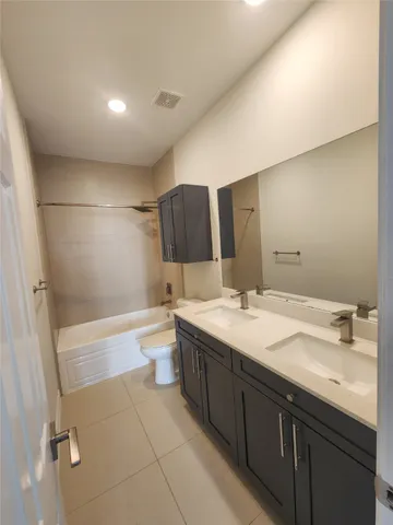 a bathroom with a granite countertop sink mirror toilet and bathtub