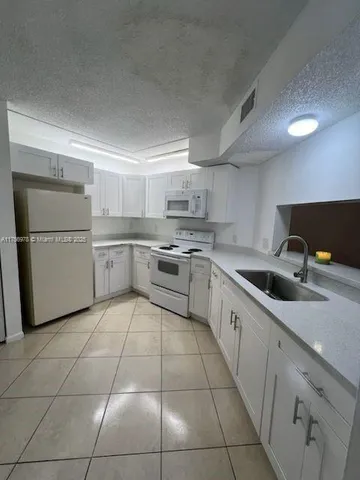 a kitchen with cabinets and white stainless steel appliances