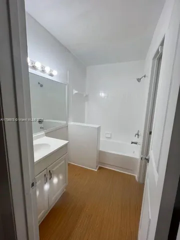 a bathroom with a sink a tub and a mirror