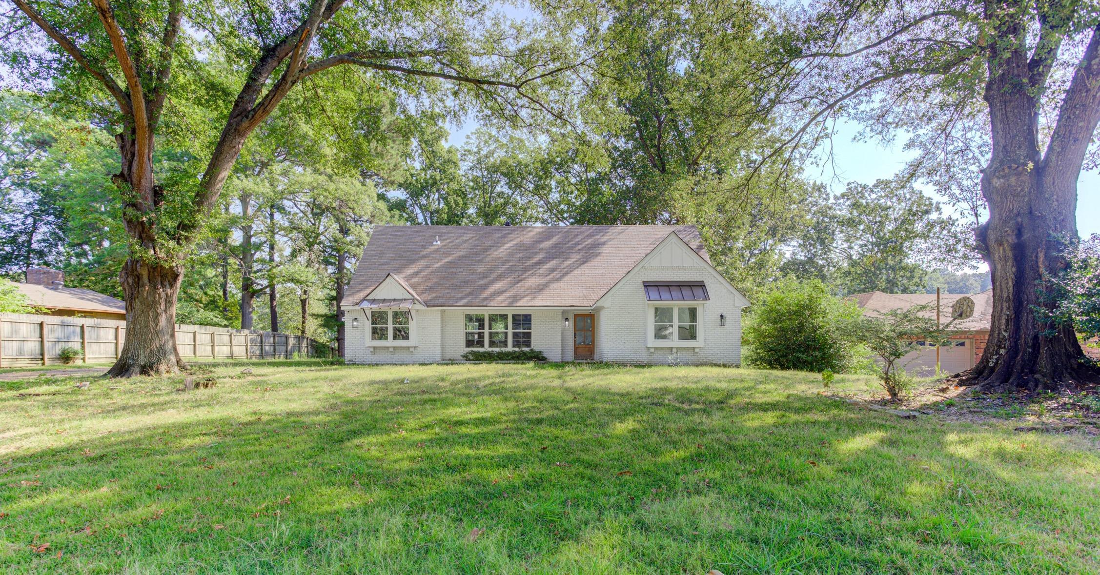 3914 Springfield Drive Memphis, TN 38128 - Photo 5 of 33 a house that is sitting in the grass with large trees