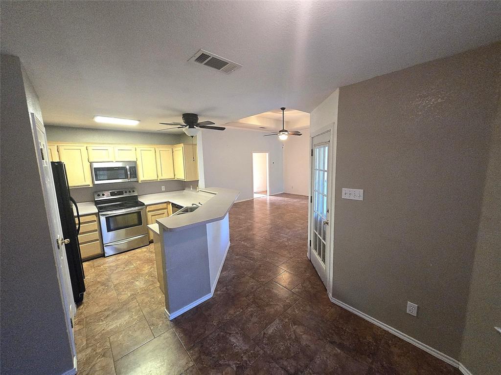 604 Valleyridge Court Decatur, TX 76234 - Photo 5 of 35 a large kitchen with a sink and dishwasher a stove top oven with wooden floor