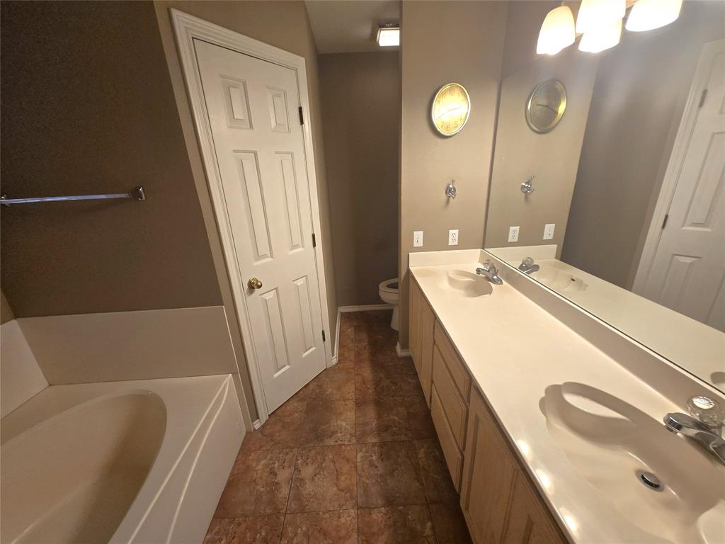 604 Valleyridge Court Decatur, TX 76234 - Photo 15 of 35 a bathroom with a sink a tub and a mirror