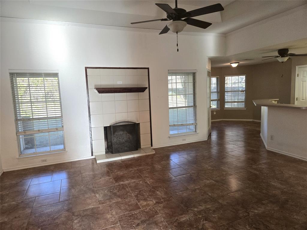 604 Valleyridge Court Decatur, TX 76234 - Photo 30 of 35 a view of a livingroom with a fireplace a ceiling fan and windows
