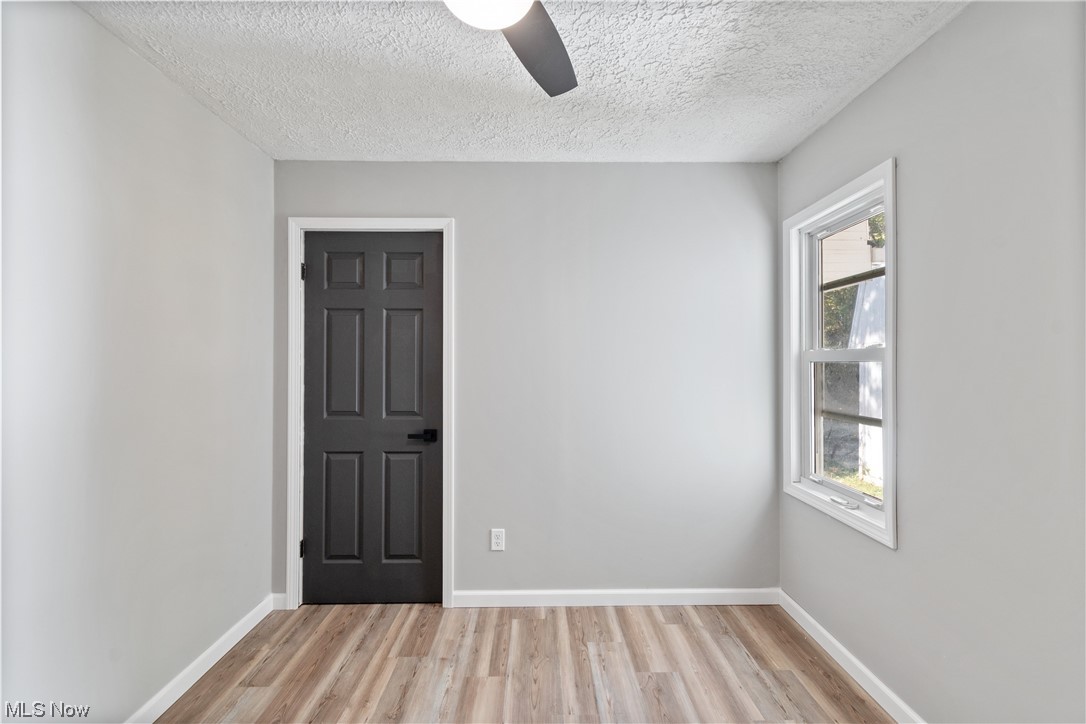 59636 Broadview Road Shadyside, OH 43947 - Photo 20 of 31 Wood floored empty room with a textured ceiling, a healthy amount of sunlight, and ceiling fan