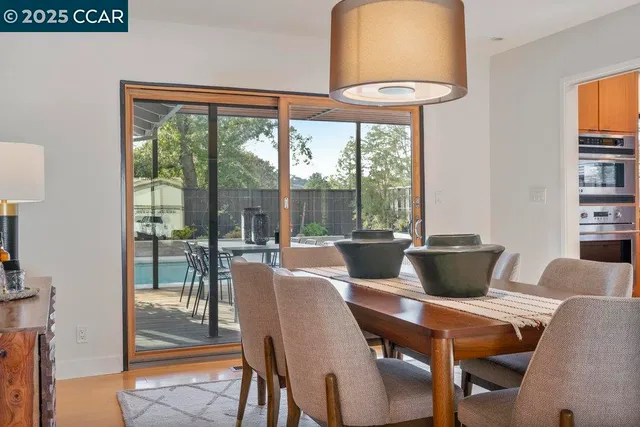 a kitchen with stainless steel appliances granite countertop a refrigerator a stove and a sink with wooden floor