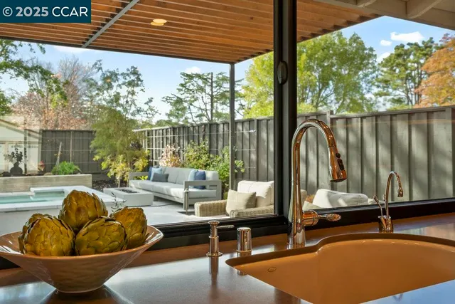 a living room with furniture kitchen view and a large window