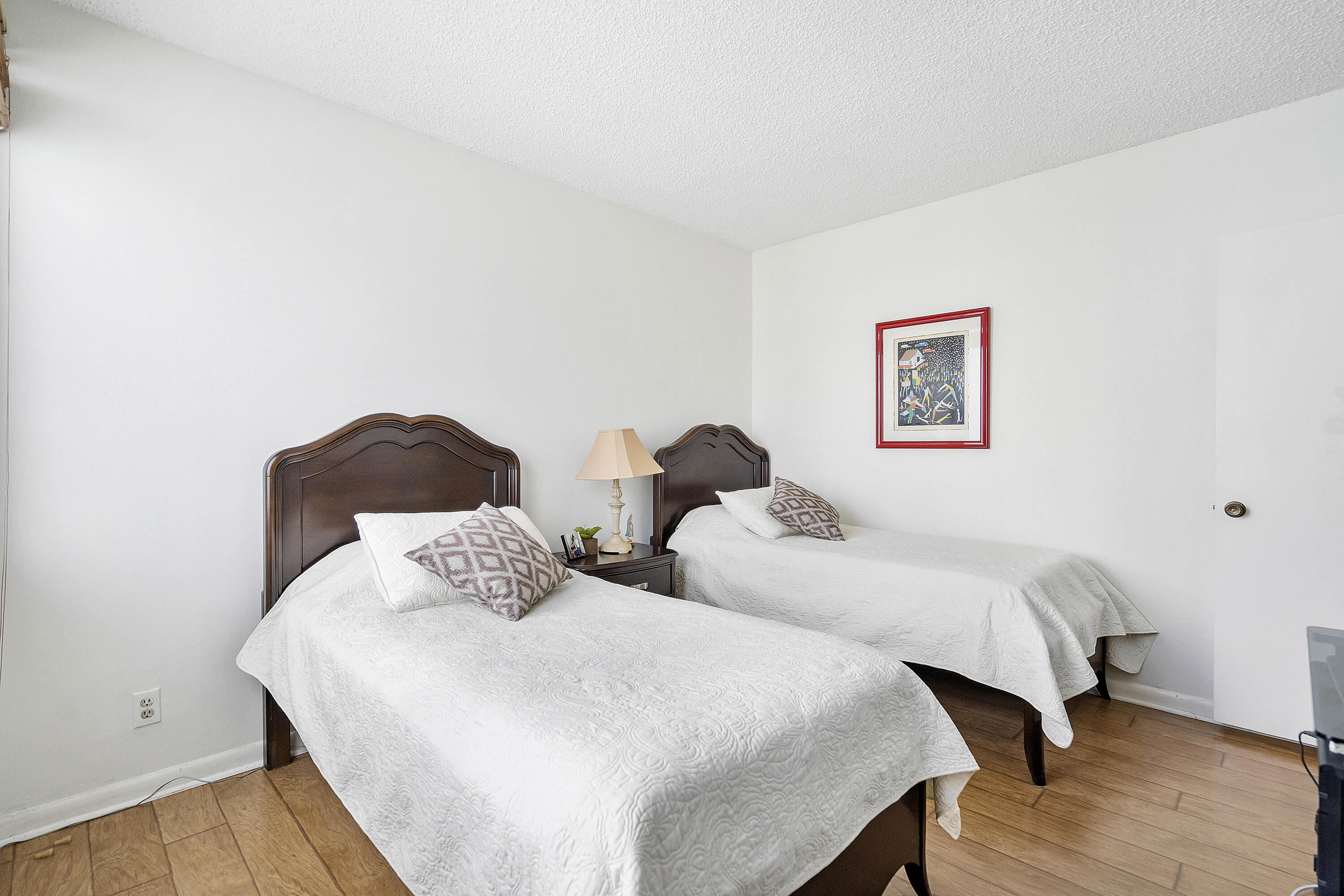 3706 Bridgewood Drive, Unit 3706 Boca Raton, FL 33434 - Photo 23 of 79 a bedroom with two beds and wooden floor