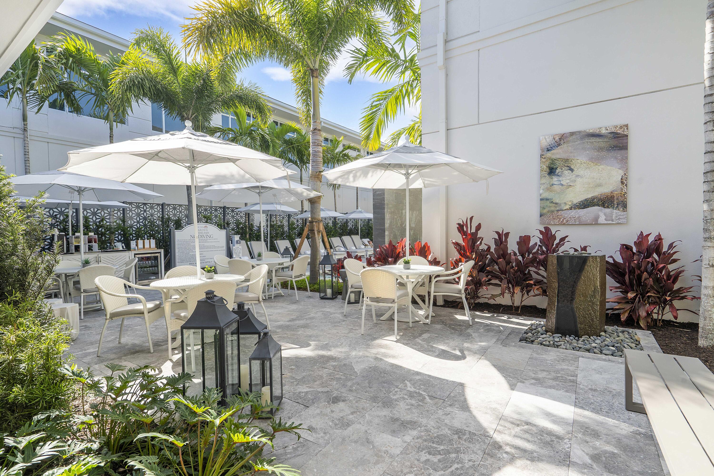 3706 Bridgewood Drive, Unit 3706 Boca Raton, FL 33434 - Photo 44 of 79 a view of a patio with a table and chairs under an umbrella