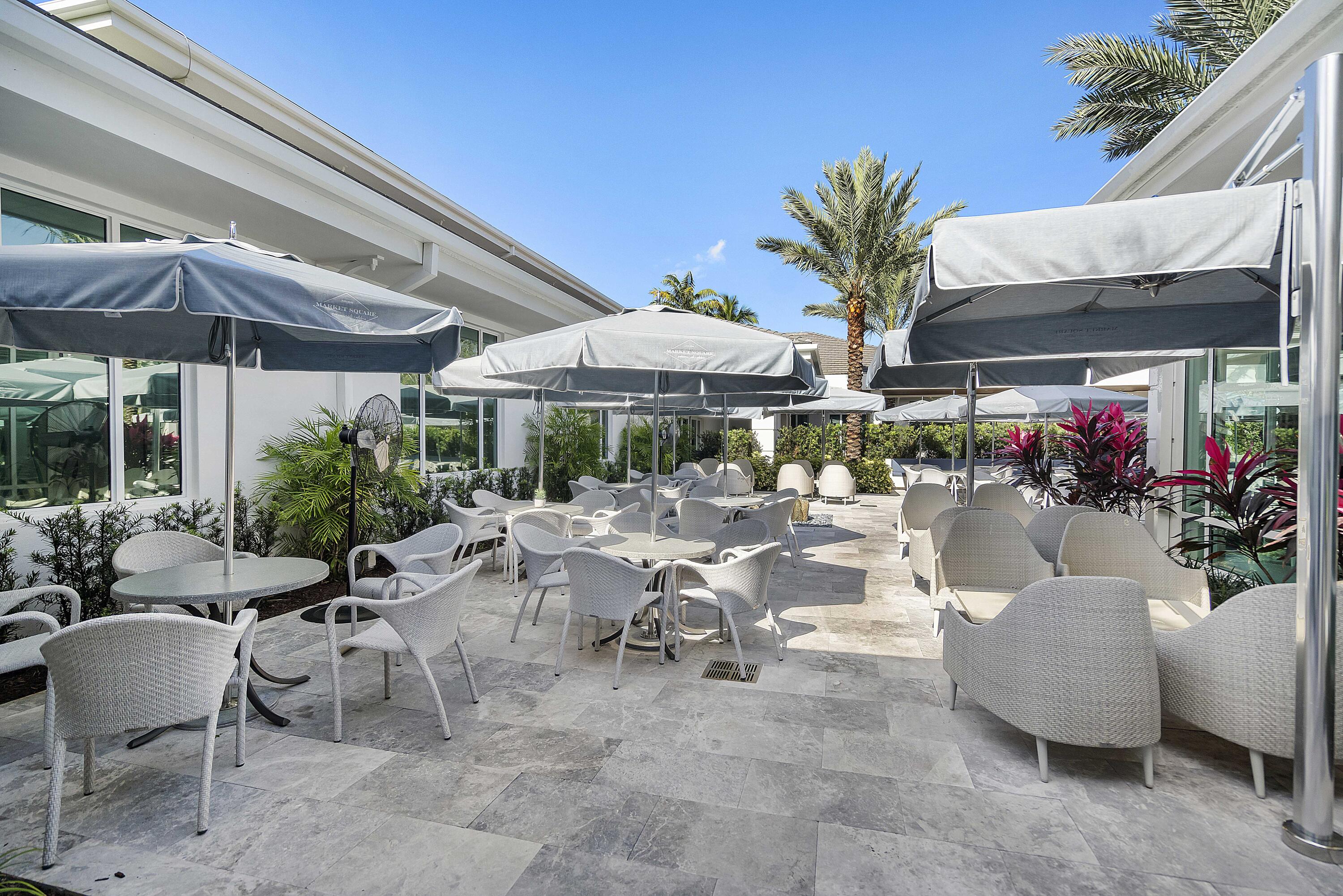 3706 Bridgewood Drive, Unit 3706 Boca Raton, FL 33434 - Photo 5 of 79 a view of a patio with dining table and chairs under an umbrella with a barbeque