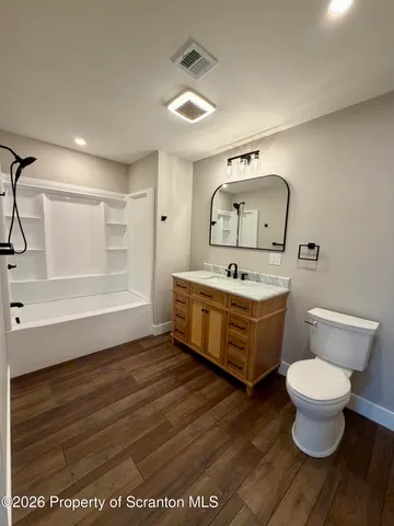 a bathroom with a sink mirror vanity and toilet