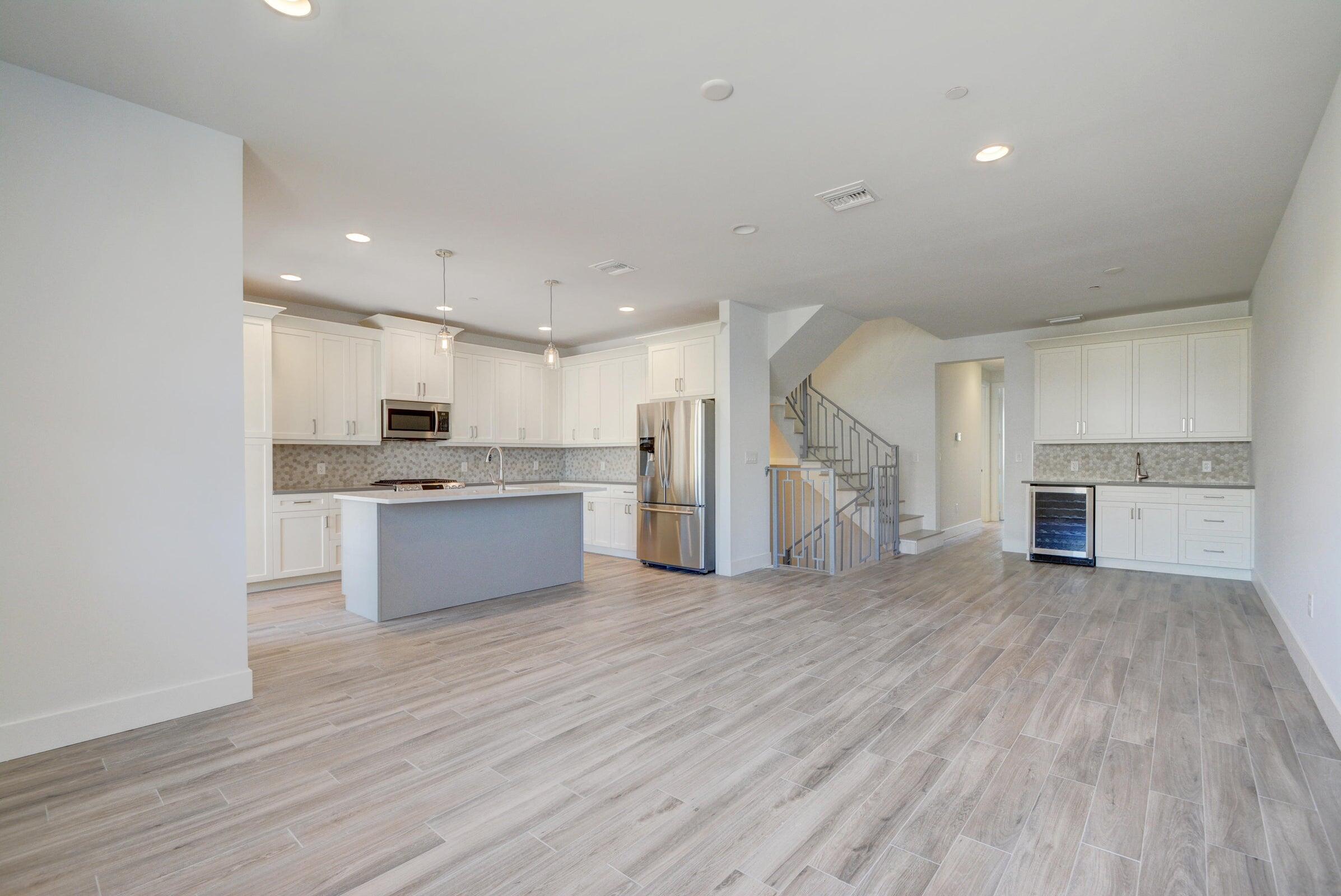 3770 County Line Road, Unit C2 Tequesta, FL 33469 - Photo 12 of 27 a large white kitchen with a stove a sink dishwasher and a oven with wooden floor