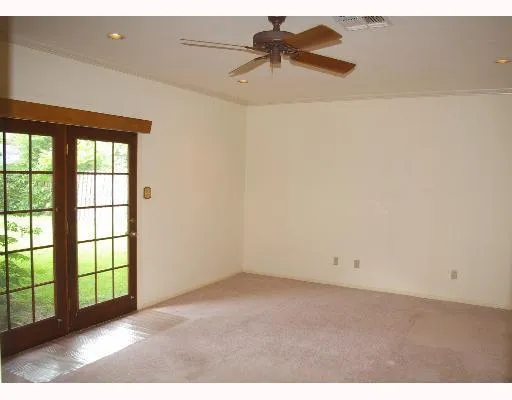 an empty room with a window and a ceiling fan
