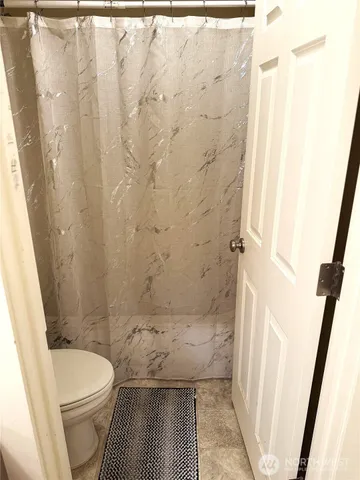 a white toilet sitting next to a bath tub