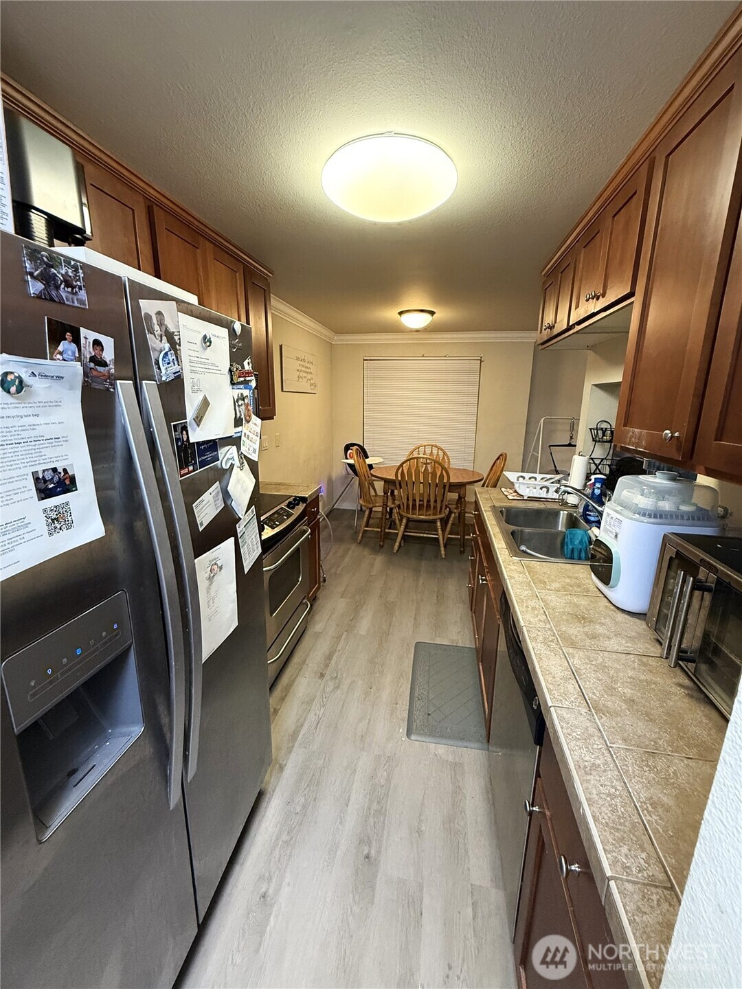28716 18th Avenue South, Unit Y203 Federal Way, WA 98003 - Photo 4 of 37 a kitchen with stainless steel appliances granite countertop sink stove refrigerator and wooden floor