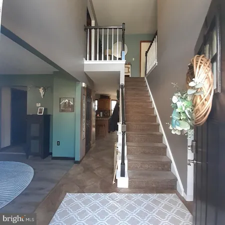 a view of entryway and hall with wooden floor