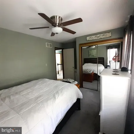 a bedroom with a bed and a large mirror