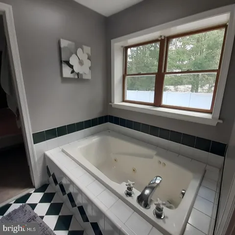 a bathroom with a bathtub and a window