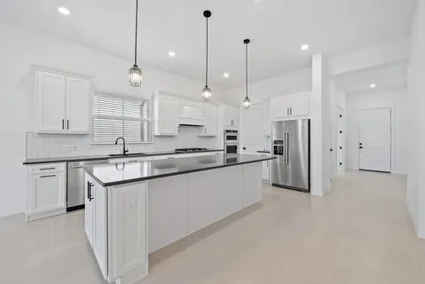a view of a kitchen with a sink stainless steel appliances and cabinets