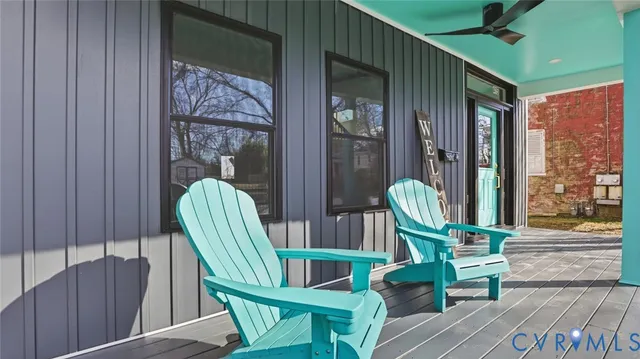 a view of a white building with large windows and a table and chairs in patio