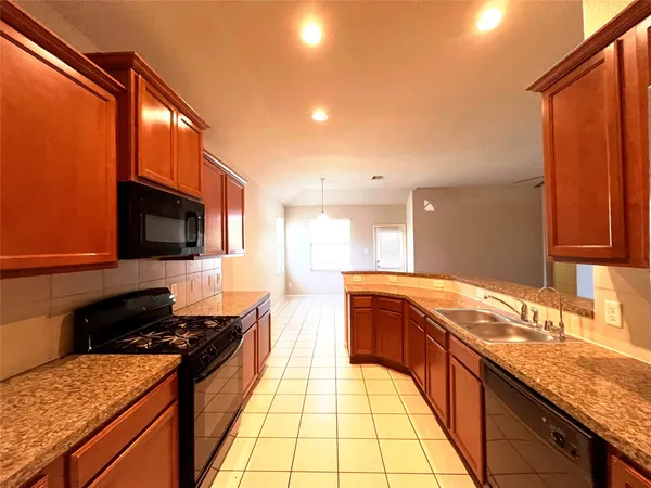a large kitchen with granite countertop a stove and a sink