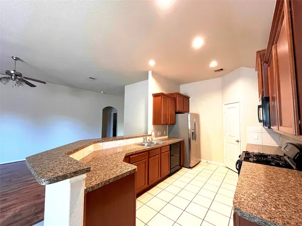a kitchen with a sink refrigerator and cabinets