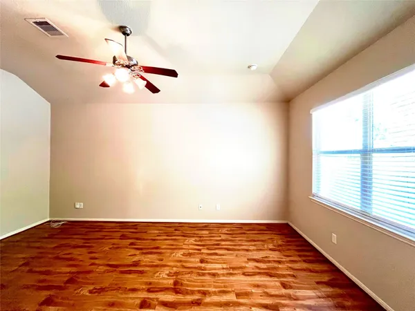 a view of a room with wooden floor and fan