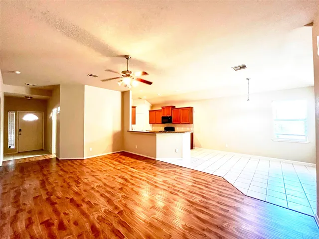 a large kitchen with granite countertop a sink and cabinets