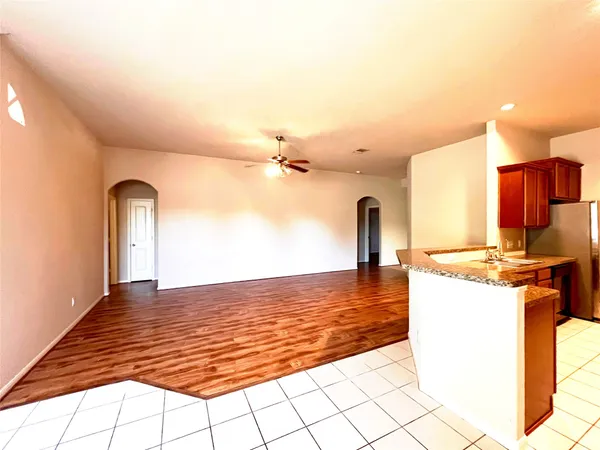 a view of a kitchen with kitchen island a stove a sink cabinetry and entryway