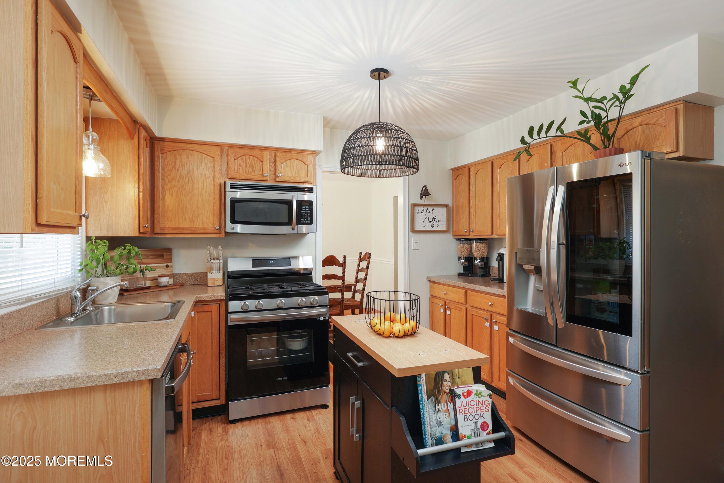 1618 Whitcomb Road Forked River, NJ 08731 - Photo 9 of 28 a kitchen with stainless steel appliances granite countertop a refrigerator a stove top oven a sink dishwasher and wooden cabinets with wooden floor