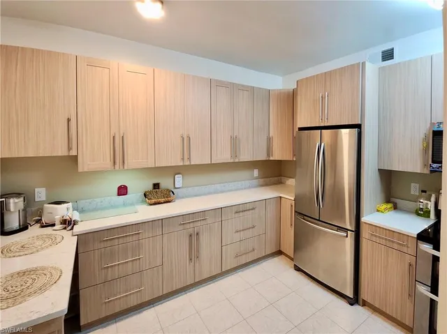 a kitchen with a refrigerator sink and cabinets
