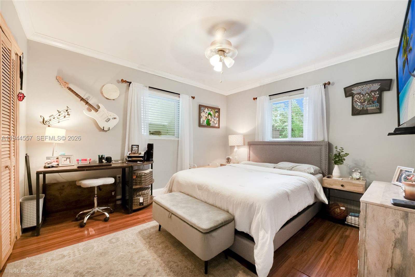 8265 Southwest 119th Street Miami, FL 33156 - Photo 11 of 34 a bedroom with a bed a desk and chair with wooden floor