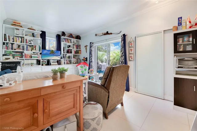 a dining room with stainless steel appliances a couch and a bookshelf with wooden floor
