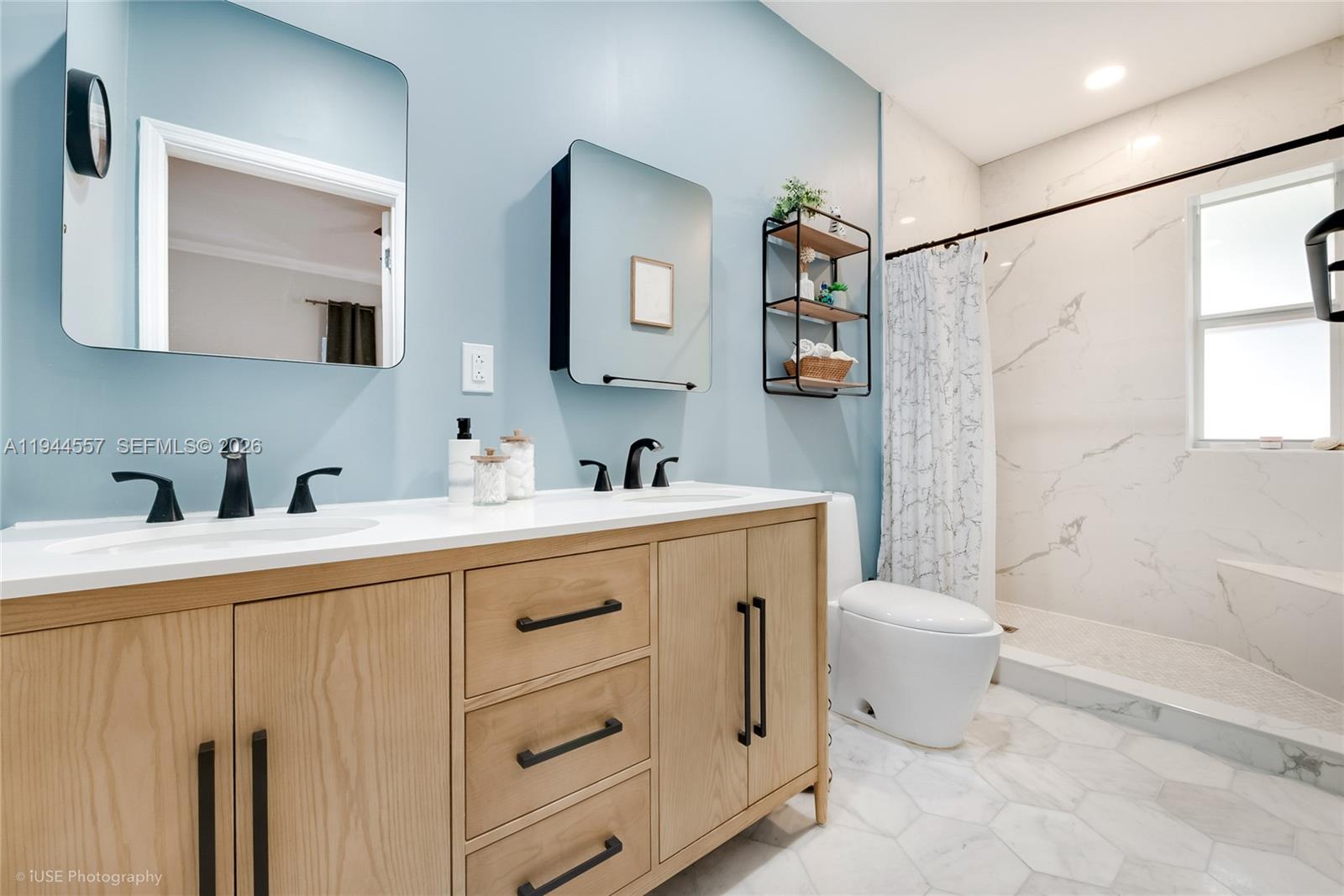 8265 Southwest 119th Street Miami, FL 33156 - Photo 19 of 34 a spacious bathroom with a double vanity sink a mirror a toilet and a bathtub