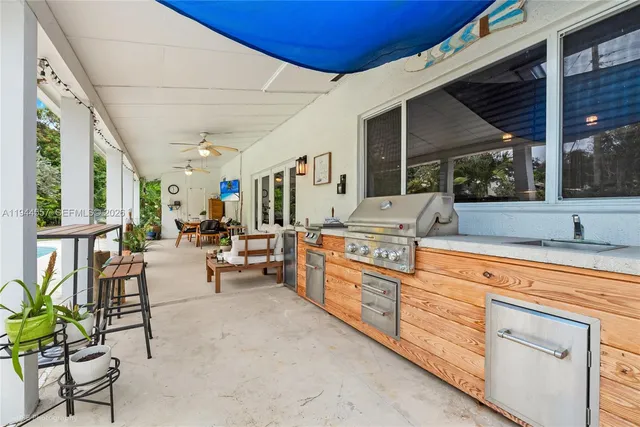 a open kitchen with granite countertop a sink and a white wooden cabinets