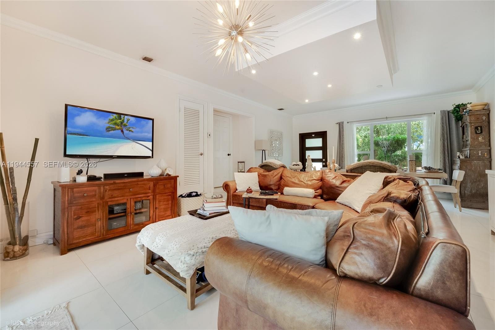 8265 Southwest 119th Street Miami, FL 33156 - Photo 8 of 34 a living room with furniture a flat screen tv and a floor to ceiling window