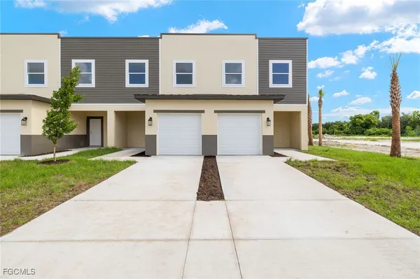 a front view of a house with a yard and garage