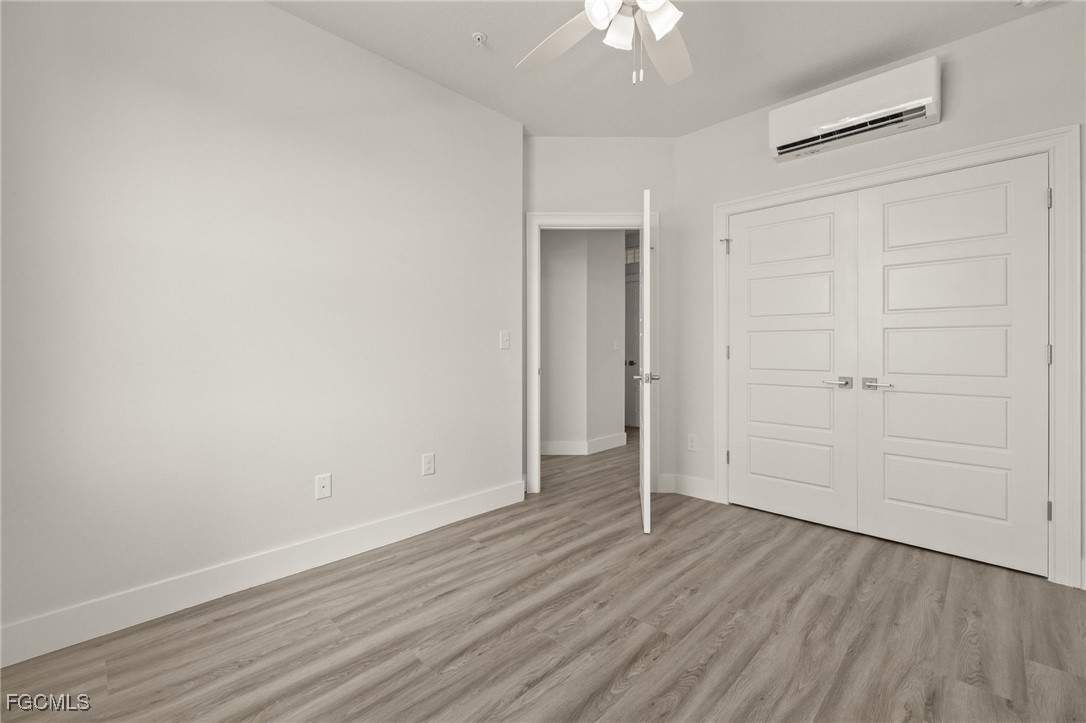 14985 Sunset Eve Loop Fort Myers, FL 33919 - Photo 13 of 18 an empty room with wooden floor closet and windows